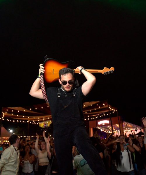 Guitarrista de Palmera Beat levantando su guitarra durante su presentación en vivo en Vino al Parque Medellín 2026.